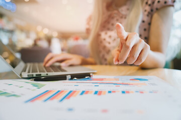 Poster - Business concept. Businesswoman Analyzing Data on Laptop with Charts Displayed