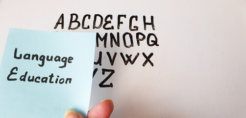 Fototapete - LANGUAGE EDUCATION text, inscription, note on the background of the board with the English alphabet, language learning. Language education concept.