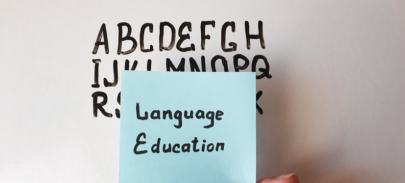 LANGUAGE EDUCATION text, inscription, note on the background of the board with the English alphabet, language learning. Language education concept.