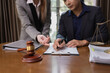 © SOMKID - Two Lawyer with Document Paper and Hammer on Wood table,  Judge's Gavel, Law, Justice Symbol, Agreement and Partnership Concept,