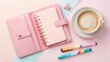 © mdsamsul - Flat lay of pink planner, coffee cup, and pens on pastel background for office or personal use