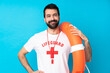 © luismolinero - Lifeguard man over isolated blue background posing with arms at hip and smiling