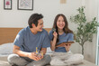 © surachetkhamsuk - Young Asian couple shopping online while using digital tablet at home, Couple using credit card to pay bills or to book a room for vacation, making an online purchase