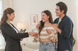© surachetkhamsuk - Estate agent hands house keys to the client. Asian woman realtor gives keys to the couple buyer while standing in mockup house, Real estate