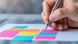 © KWANMANAT - Hand Writing Down Ideas on Colorful Sticky Notes on Desk