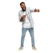 © Wasabi - Man laughing while pointing with both hands, wearing casual light denim shirt and jeans, expressing amusement and joy in full body pose