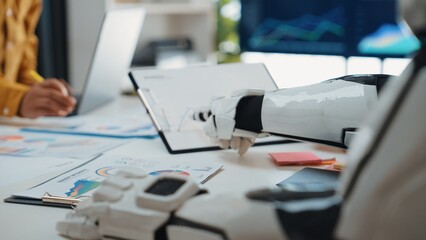 Poster - A robotic hand interacts with various charts and reports on a modern office table, showcasing the blending of technology and teamwork in data analysis.Noogenesis