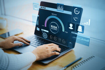 Poster - Business person analyzing digital risk management interface on laptop at desk with futuristic financial data dashboard and corporate charts.