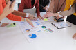 © SOMKID - Teamwork of business people brainstorming with financial data graph analysis on the table in the meeting room.