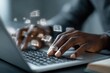 © 12 - Close-up of dark-skinned hands typing on a laptop with book icons hovering