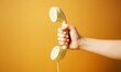 © Pixels Hunter - Hand holding vintage telephone receiver on yellow background, retro communication concept with vibrant colors and strong visual contrast. Ai generative.