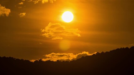 Wall Mural - Timelapse of dramatic sunset with orange sky in a cloudy day.