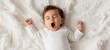 © Natali  - The adorable baby yawning peacefully on a soft white blanket.