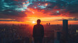 © Serega - Man Silhouetted Against a Dramatic Sunset Over a Cityscape. Urban observation, peace and contemplation.