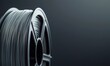 © Yevheniiya - A close-up shot showcases a spool of filament, a crucial material for 3D printing, against a sleek, dark backdrop, ideal for innovation and technology themes.
