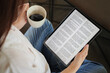 © asiandelight - woman hand holding coffee cup and tablet, reading text on tablet device with a touchscreen interface for digital press article feed in the morning. mockup media publication website on portable tablet