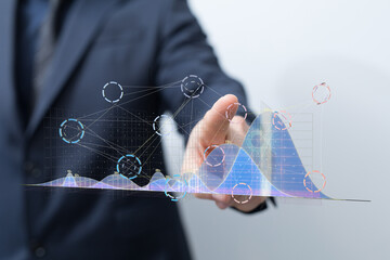 Poster - Stock photo of a businessman interacting with projected data graphs and charts, showcasing business analytics and insights.