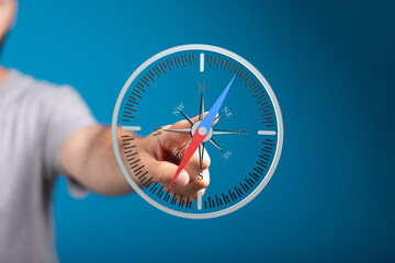 Poster - Stock photo of a hand interacting with a digital compass, symbolizing guidance and direction. Ideal for business, navigation, and technology concepts.