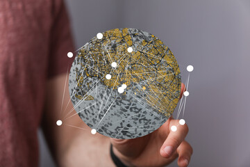 Poster - Person holding a digital globe showcasing interconnected city networks.  Ideal for technology, globalization, and connectivity concepts.