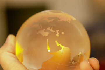 Poster - Close-up of a hand holding a glass globe, showcasing a world map.  Perfect for global concepts.