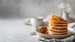 © Moritz - Close-up of a stack of fluffy golden pancakes being drizzled with rich, golden honey from a wooden dipper, creating a delicious breakfast scene