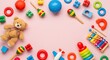 © abufahim - Colorful collection of baby and toddler toys arranged on a pink background.