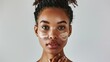 © Dao - Beauty and skin care. Skincare hydration and oil balance. Portrait of African American woman with afro braids hairstyle is applying a cream smear on her face and standing against white background
