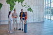 © we.bond.creations - Four managers are discussing global strategy in a modern office with a vertical garden world map made of moss on a concrete wall