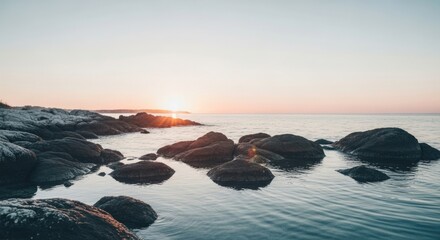 Wall Mural - Stunning sunset over rocky shoreline with calm ocean waters