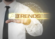 © New Africa - Businessman using virtual screen to find hot tendencies, new ideas, popular directions against grey background, closeup. Search bar with word Trends and globe