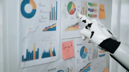 Poster - A robotic hand points at various business charts and graphs mounted on a wall, symbolizing the integration of technology in market analysis and strategy development.Noogenesis