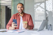 © Liubomir - A smiling man using a credit card and smartphone, with a laptop and notebook on the table.