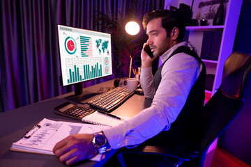 Poster - Smart businessman calling partner or investor on smartphone writing memo market data on paper work report folder to analyze sales channel discipline's product service at neon dark light room. Surmise.