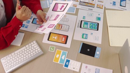 Poster - Hand focus of startup company employee present user interface prototype for mobile application to smart co-worker in office workspace. UX UI designer praise function of icon design on paper. Synergic