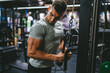 © Miljan Živković - athlete man do exercise for triceps on the exercise cable machine