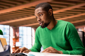 Poster - Man at home office desk crosschecking information between laptop screen and paper files, seeing inaccuracies. Remote worker confused by missing data in documents, comparing with notebook display