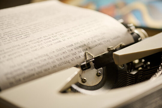 Close up showing vintage typewriter with typed page emerging, focusing on mechanical keys and textured paper, capturing detail of classic writing process in retro office setting
