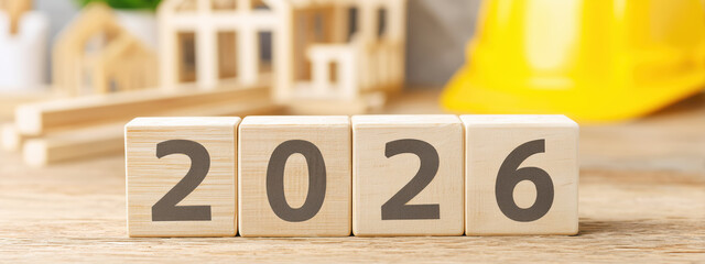 Poster - Wooden Blocks with Year 2026 Representing Future Planning and Construction Trends in a Cozy Workspace with Miniature Structures and Tools