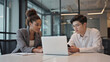 © STBSTD - Black adult woman Asian adult man business professionals collaborate discuss project laptop smartphone modern office workspace meeting teamwork strategy data review
