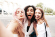 © halayalex - Three young beautiful smiling hipster female in trendy summer clothes.Sexy carefree multiracial women posing on the street background.Positive models having fun in sunglasses. Taking Pov selfie