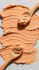 Poster - Overhead view of orange cream spread with wooden spoons on a light background close up shot