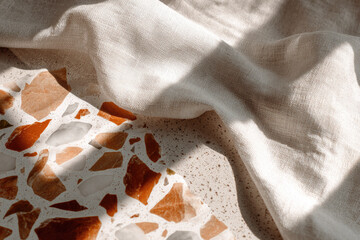 Aufkleber - Warm beige terrazzo surface with brown and white stone fragments, soft natural linen fabric, sunlight and shadow create calm, cozy atmosphere