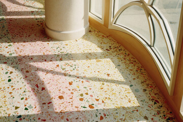 Aufkleber - Terrazzo flooring with colorful stone chips, sunlight streaming through large arched window, warm and inviting atmosphere, modern interior design
