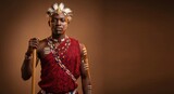 African tribesman in traditional red attire and ceremonial face paint, posing with a wooden staff in a studio with ample copy space.