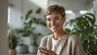 © Supanat - Smiling woman with short hair and glasses using smartphone indoors on bright day.