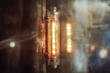 Poster - Vintage industrial light fixture illuminating a reflective surface in a rustic setting