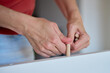 © Lazy_Bear - Female hands insert wooden dowel into white furniture board during assembly. Woman connects furniture parts using wooden pegs