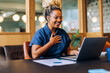 © (JLco) Julia Amaral - Smiling woman enjoying a video call with a laptop in a cozy office