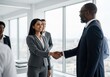 © Yhs City - Diverse Business People Shaking Hands in Modern Office Setting