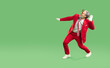 © Studio Romantic - Horizontal shot of joyful man dressed in red suit like Santa Claus, dances and has fun, moves actively to music, isolated over vivid green background, blank space for your advertising content.